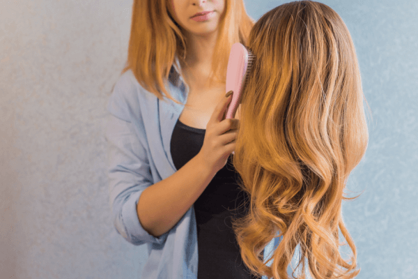 Woman Styling Her Long, Wavy Hair Wig